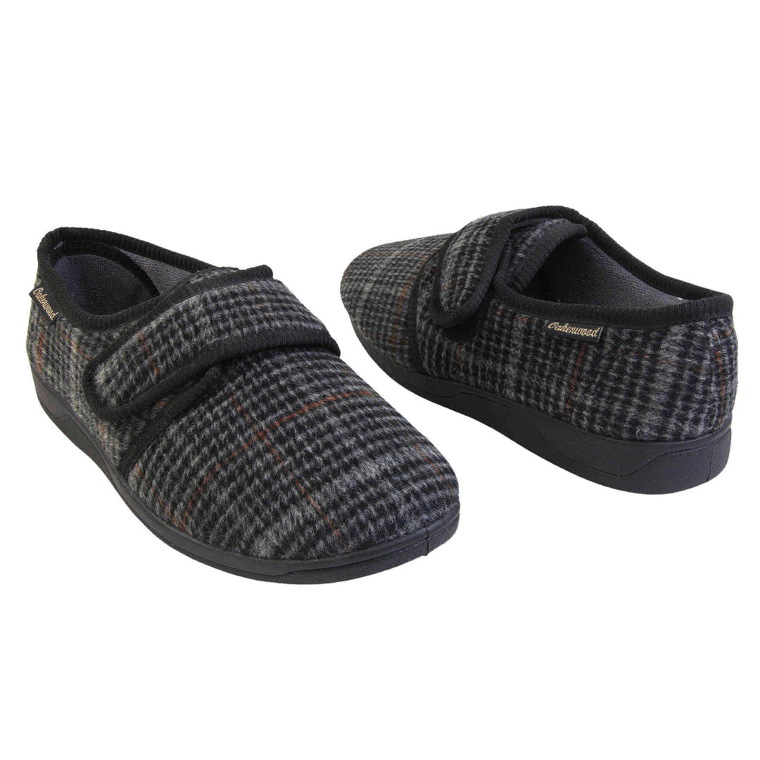 Mens adjustable slippers. Full back slippers with a black and grey check upper and black edging around the strap and collar of the shoe. Touch fasten strap across the bridge of the foot. Chunky black synthetic sole. Both feet from an angle about an inch apart and facing top to tail.