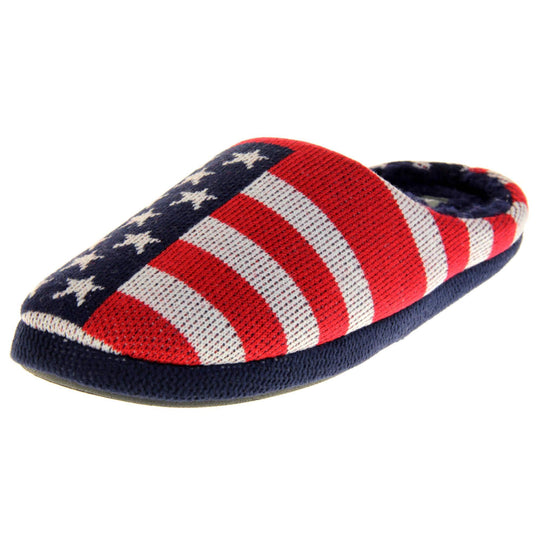Mens American Flag slippers. Mens slippers in a mule style. With red, white and blue USA flag knit fabric upper. Blue faux fur lining. Black hard synthetic soles with grip to the base. Left foot at an angle.