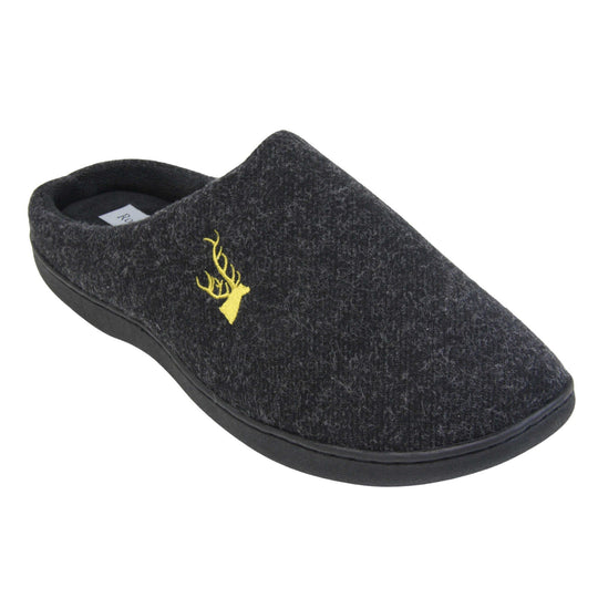 Mens backless slippers. Mule style slippers with black fleece uppers with an embroidered stag head to the top, on the outside. Black terry lining and firm black sole. Right foot at an angle.