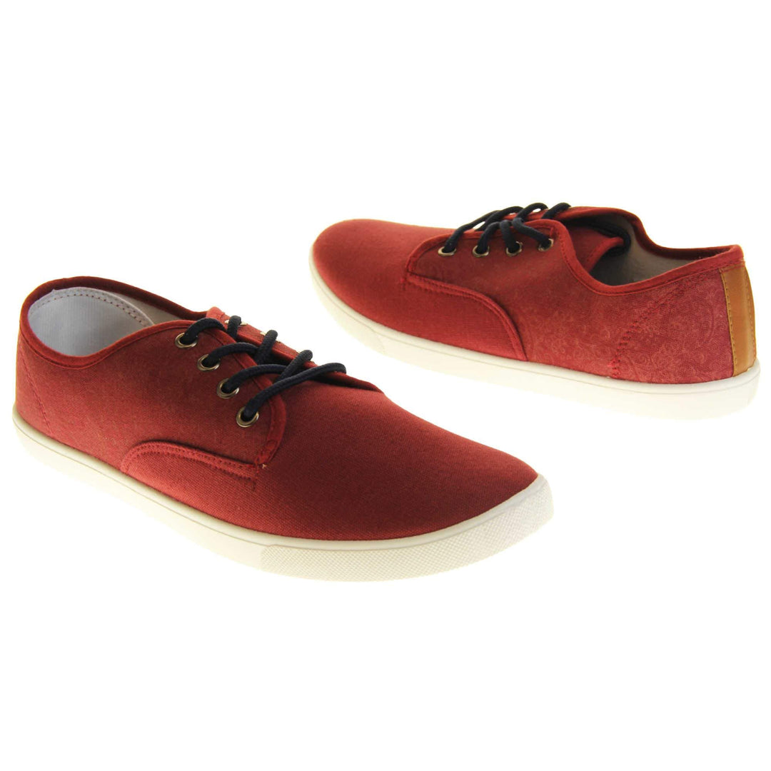 Mens canvas pumps. Burgundy red canvas upper with black laces. White synthetic sole and white textile lining. Both feet at a slight angle facing top to tail.