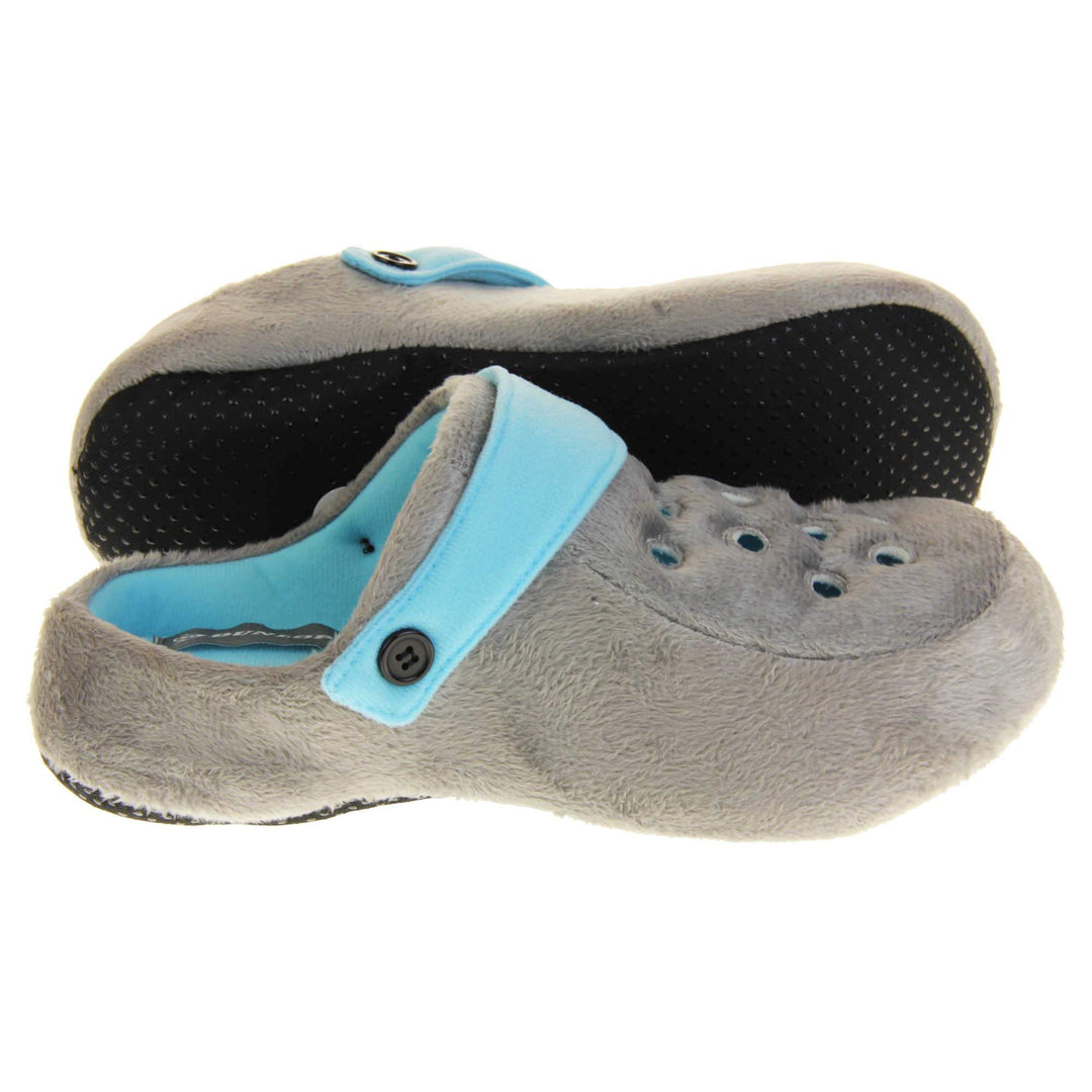 Mens clog slippers. Grey fabric clog style novelty slipper. Cut out holes on the upper. Light blue strap that goes along the back of your heel. The strap can be moved along the top of the shoe instead to make the shoe a mule. Both feet from side profile with left foot on its side to show the sole