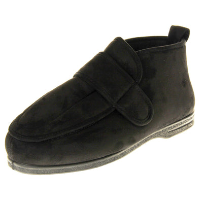 Mens extra wide slippers. Mens orthopaedic slippers in an ankle boot style. With a soft black faux suede upper and black textile lining. With an adjustable touch close top. Thick black outdoor sole. Left foot at an angle.