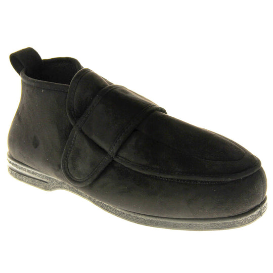 Mens extra wide slippers. Mens orthopaedic slippers in an ankle boot style. With a soft black faux suede upper and black textile lining. With an adjustable touch close top. Thick black outdoor sole. Right foot at an angle.