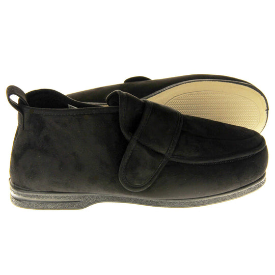 Mens extra wide slippers. Mens orthopaedic slippers in an ankle boot style. With a soft black faux suede upper and black textile lining. With an adjustable touch close top. Thick black outdoor sole. Both feet from side profile with the left foot on its side to show the sole