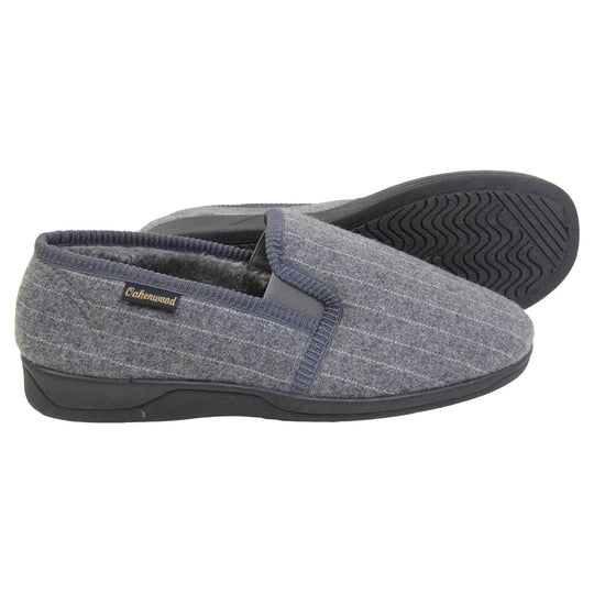 Mens full back slippers. Grey wool effect upper with white pin stripes. Grey elasticated panels joining the tongue to the top of the slippers. Small black label on the outside rim, with Oakenwood branding sewn in gold. Grey faux fur lining. Both feet from side profile with left foot on its side to show the sole.