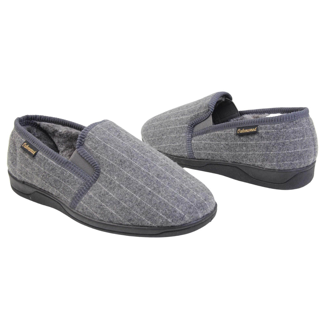 Mens full back slippers. Grey wool effect upper with white pin stripes. Grey elasticated panels joining the tongue to the top of the slippers. Small black label on the outside rim, with Oakenwood branding sewn in gold. Grey faux fur lining. Both feet facing top to tail, at an angle.