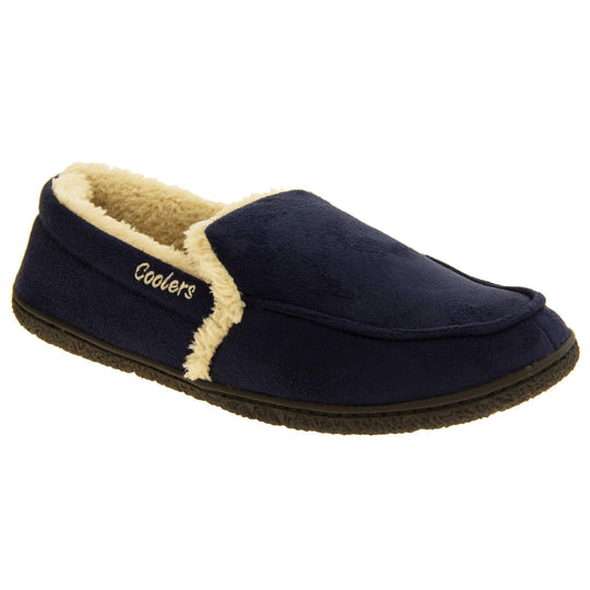 Mens lined slippers. Full back slippers with navy blue faux suede upper with cream synthetic fur detail. Cream Coolers branding on the outside. Cream faux fur lining. Black sole with grip. Right foot at an angle.