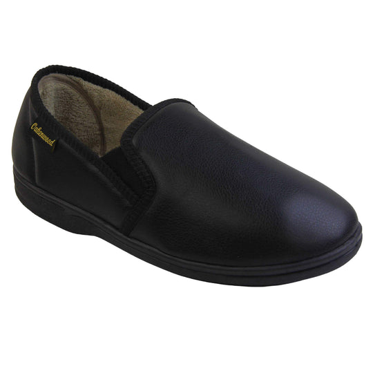 Mens memory foam slippers. Black faux leather classic full back slipper with beige fleece lining. Right foot from an angle.