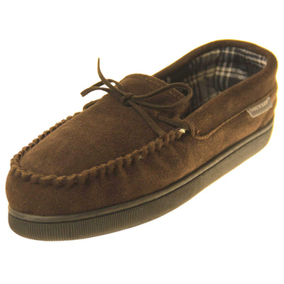 Mens moccasin slippers. Moccasin style slipper with brown suede upper and leather bow to the top. Grey Dunlop label to the outside. Grey and white plaid textile lining. Black rubber sole. Left foot at an angle.