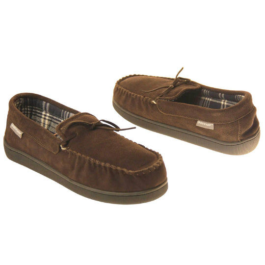 Mens moccasin slippers. Moccasin style slipper with brown suede upper and leather bow to the top. Grey Dunlop label to the outside. Grey and white plaid textile lining. Black rubber sole. Both shoes spaced apart, facing top to tail at an angle.