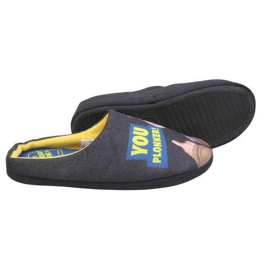 Mens mule novelty slippers. Mens slippers in a mule style. With black fabric upper with Del Boy from Only Fools and Horses printed on it and pointing. The words you plonker! in bold yellow font outlined in blue above his pointing finger. Blue fabric insole with yellow Totters independent trading logo on. Yellow fleece lining. Black hard synthetic soles with bumpy grip to the base. Both feet from a side profile with the left foot on its side to show the sole.