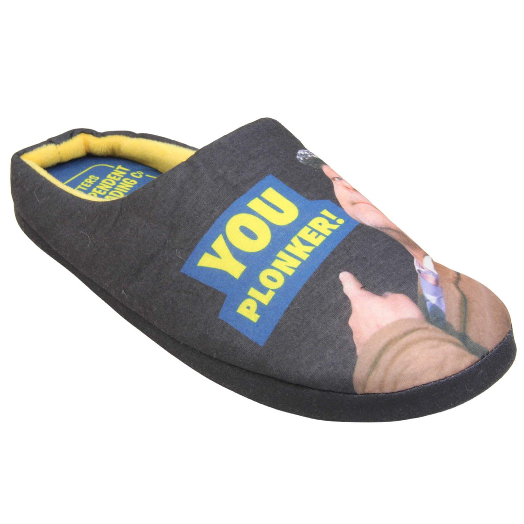Mens mule novelty slippers. Mens slippers in a mule style. With black fabric upper with Del Boy from Only Fools and Horses printed on it and pointing. The words you plonker! in bold yellow font outlined in blue above his pointing finger. Blue fabric insole with yellow Totters independent trading logo on. Yellow fleece lining. Black hard synthetic soles with bumpy grip to the base. Right foot at an angle.
