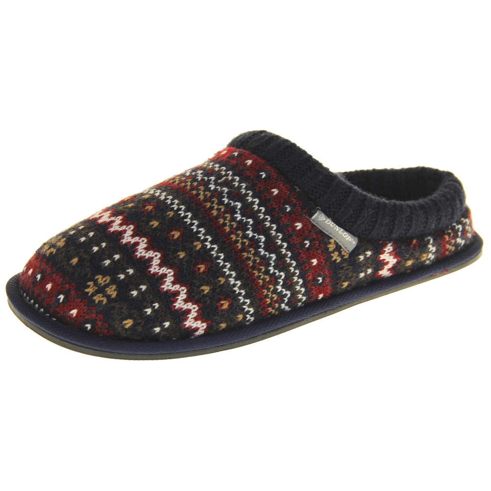 Mens navy mule slippers. Mens slippers in a mule style. With navy blue knit fabric upper with brown, red and white pattern. Cream faux fur lining. Black hard synthetic soles with grip to the base. Left foot at an angle.