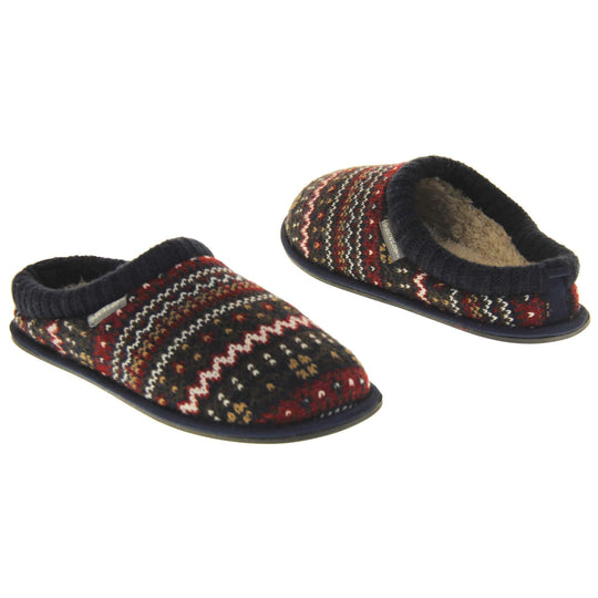 Mens navy mule slippers. Mens slippers in a mule style. With navy blue knit fabric upper with brown, red and white pattern. Cream faux fur lining. Black hard synthetic soles with grip to the base. Both feet from an angle facing top to tail.