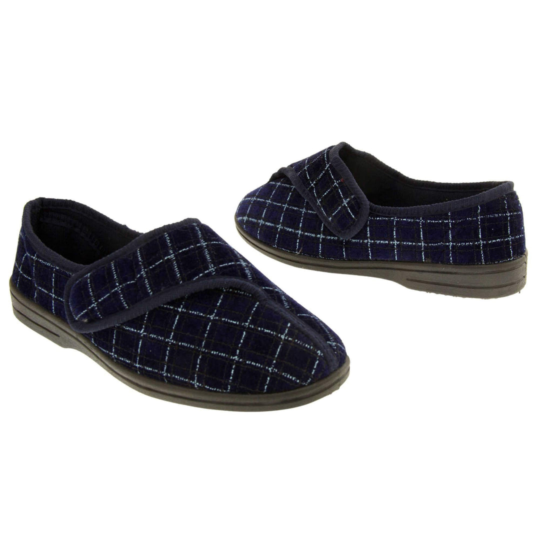 Mens orthopaedic slippers. Full back slippers with a navy and pale blue upper. Touch fasten strap across the bridge of the foot. Chunky black synthetic sole. Navy lining. Both feet from an angle about an inch apart and facing top to tail.