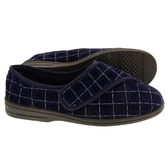 Mens orthopaedic slippers. Full back slippers with a navy and pale blue upper. Touch fasten strap across the bridge of the foot. Chunky black synthetic sole. Navy lining. Both feet from side profile with left foot on its side to show the sole.