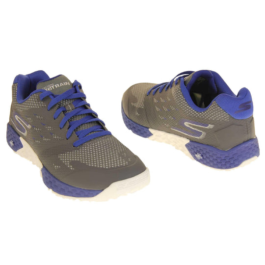 Mens Skechers go train. Grey mesh upper with darker grey overlay. Blue laces and textile lining and small amount of blue detailing. Blue and white Skechers logo to the side of the heel and chunky white and blue outsole with grip. Both feet at a slight angle facing top to tail.
