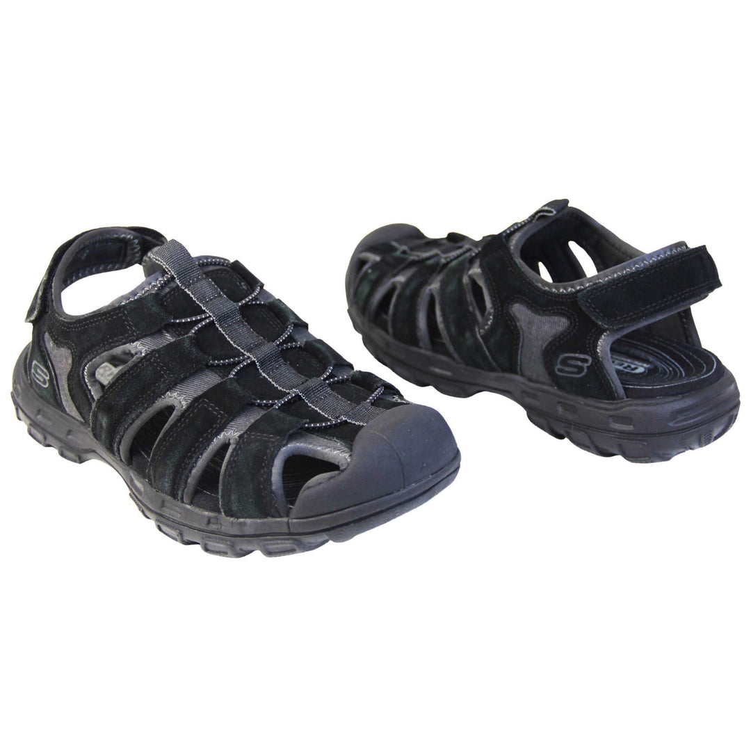 Mens Skechers sandals. Tradition style sandal with grey fabric and black suede leather strappy upper. Black rubber toe caps and black synthetic sole with deep grips to the bottom. Elasticated laces to the front of the shoe and touch fasten strap around the back of the heel. Both feet about an inch apart at an angle facing top to tail.