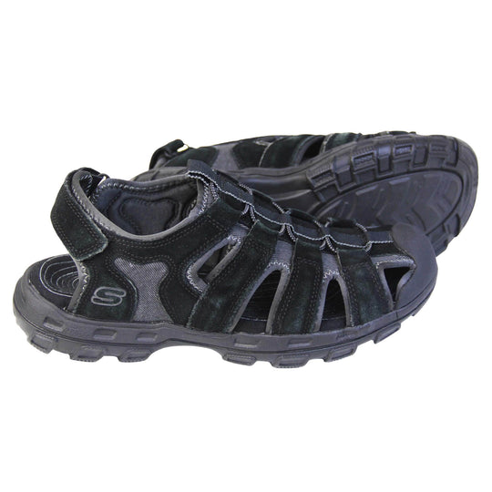 Mens Skechers sandals. Tradition style sandal with grey fabric and black suede leather strappy upper. Black rubber toe caps and black synthetic sole with deep grips to the bottom. Elasticated laces to the front of the shoe and touch fasten strap around the back of the heel. Both feet from side profile with the left foot on its side behind the right to show its sole.