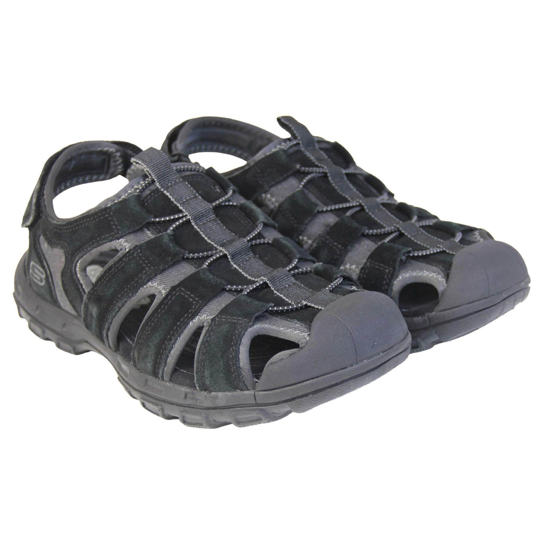 Mens Skechers sandals. Tradition style sandal with grey fabric and black suede leather strappy upper. Black rubber toe caps and black synthetic sole with deep grips to the bottom. Elasticated laces to the front of the shoe and touch fasten strap around the back of the heel. Both feet together from a slight angle.