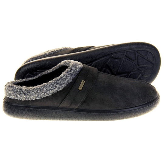 Mens slip on mules. Mens slippers in a mule style. With dark grey faux suede upper. Black fleece lining and grey faux fur collar. Black hard synthetic soles with grip to the base. Both feet from a side profile with the left foot on its side to show the sole.
