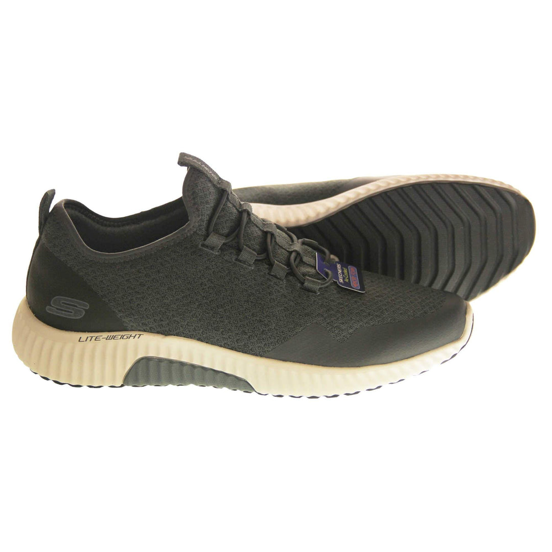 Mens slip on Skechers. Charcoal grey mesh upper with black elasticated laces for a slip on trainer. Black Skechers logo to the heel and chunky white outsole with black bottom with grip. Both feet from a side profile with the left foot on its side to show the sole.