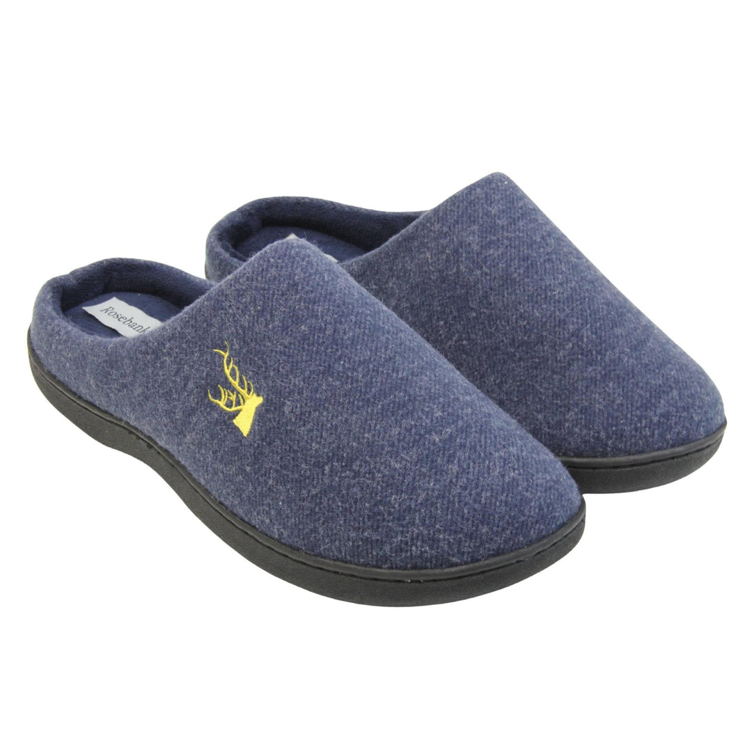 Mens slip on slippers. Mule style slippers with blue fleece uppers with an embroidered stag head to the top, on the outside. Blue terry lining and firm black sole. Both feet together at an angle.