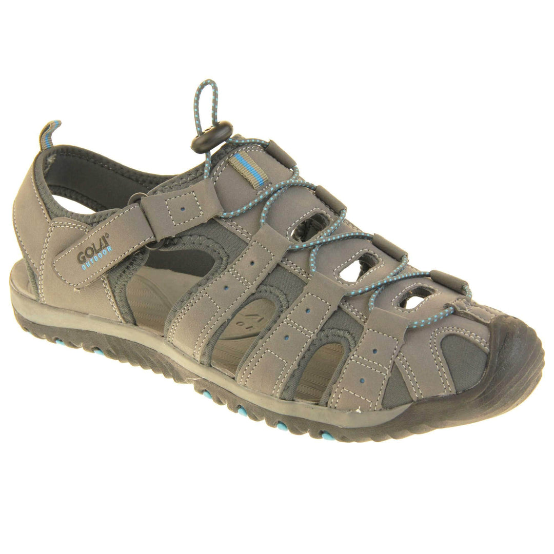 Mens walking sandals. Traditional style sandal with Light grey and dark grey fabric strappy upper. Black rubber toe caps and black synthetic sole with blue grips to the bottom. Elasticated laces to the front of the shoe and touch fasten strap by the ankle. Right foot at an angle.