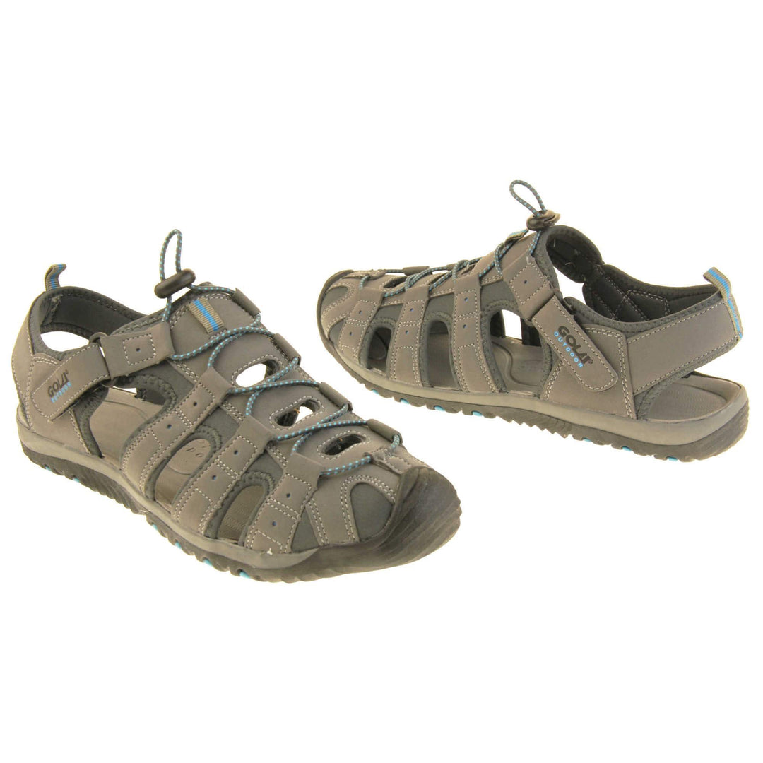Mens walking sandals. Traditional style sandal with Light grey and dark grey fabric strappy upper. Black rubber toe caps and black synthetic sole with blue grips to the bottom. Elasticated laces to the front of the shoe and touch fasten strap by the ankle. Both feet about an inch apart at an angle facing top to tail.