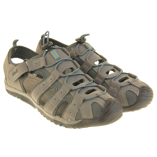 Mens walking sandals. Traditional style sandal with Light grey and dark grey fabric strappy upper. Black rubber toe caps and black synthetic sole with blue grips to the bottom. Elasticated laces to the front of the shoe and touch fasten strap by the ankle. Both feet together from a slight angle.