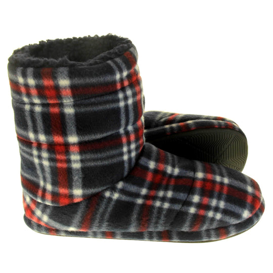 Mens warm slippers boots. Slipper boots with a soft navy fabric upper with red and white check. With a firm black synthetic sole with grip to the base. Black faux fur lining. Both feet from side profile with left foot on its side to show the sole.