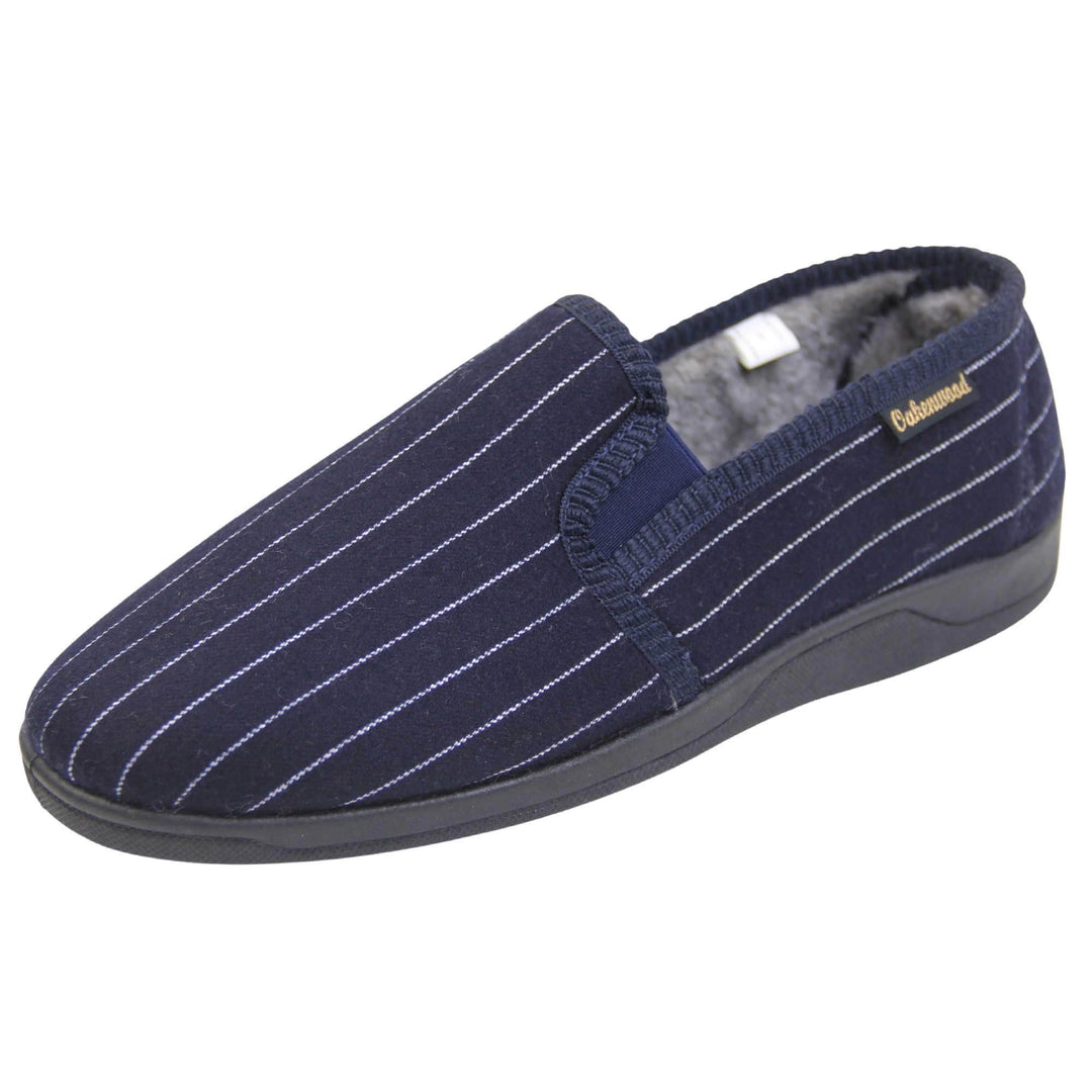 Mens warm slippers. Full back slippers with navy blue wool effect upper with white pin stripes. Navy elasticated panels joining the tongue to the top of the slippers. Small black label on the outside rim, with Oakenwood branding sewn in gold. Grey faux fur lining. Left foot at an angle.