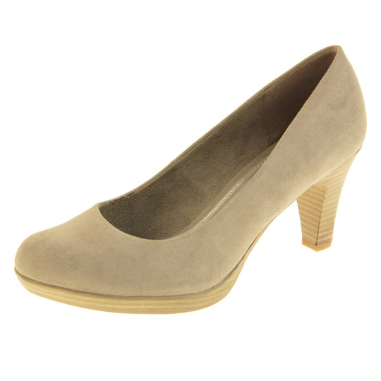 Mid heel court shoes. Womens shoes with a taupe faux suede upper. Pale gold metallic insole with Marco Tozzi branding. Taupe faux suede lining. Wood appearance mid block heel and small platform. Left foot at an angle.
