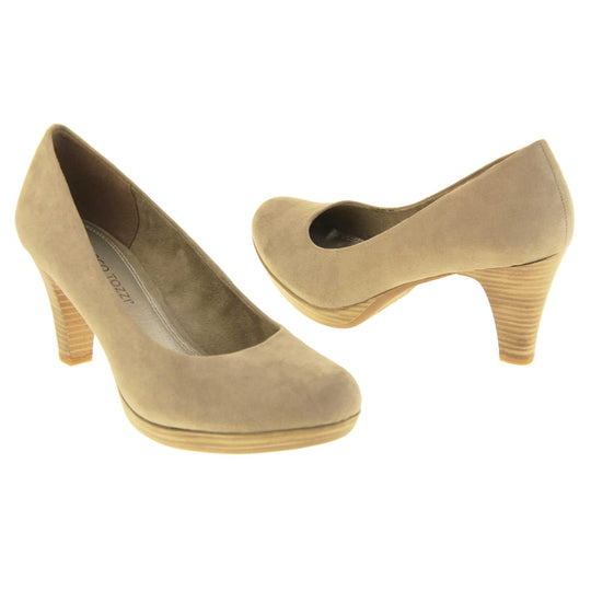 Mid heel court shoes. Womens shoes with a taupe faux suede upper. Pale gold metallic insole with Marco Tozzi branding. Taupe faux suede lining. Wood appearance mid block heel and small platform. Both feet at an angle facing top to tail.