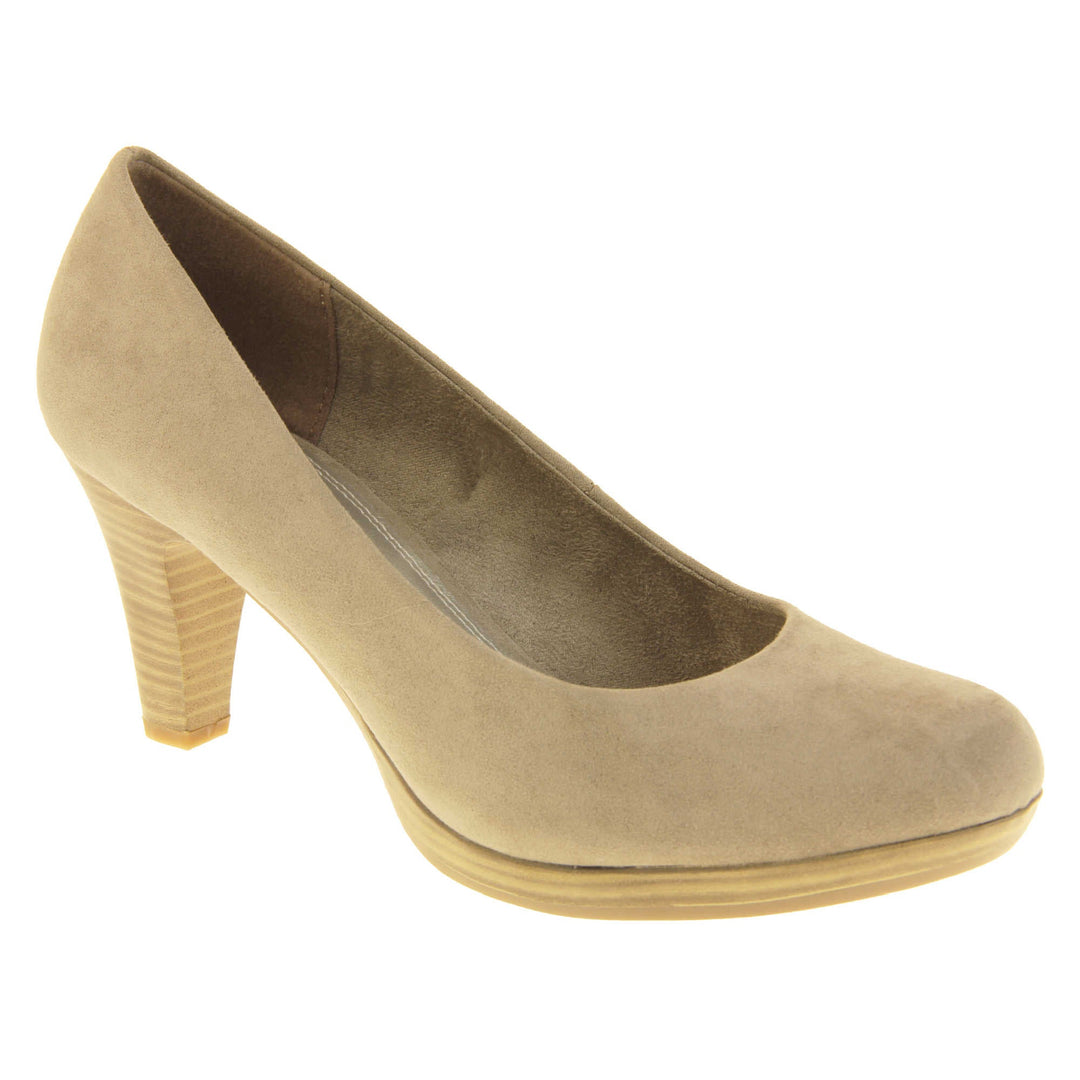 Mid heel court shoes. Womens shoes with a taupe faux suede upper. Pale gold metallic insole with Marco Tozzi branding. Taupe faux suede lining. Wood appearance mid block heel and small platform. Right foot at an angle.