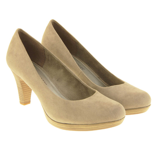 Mid heel court shoes. Womens shoes with a taupe faux suede upper. Pale gold metallic insole with Marco Tozzi branding. Taupe faux suede lining. Wood appearance mid block heel and small platform. Both feet together at a slight angle.