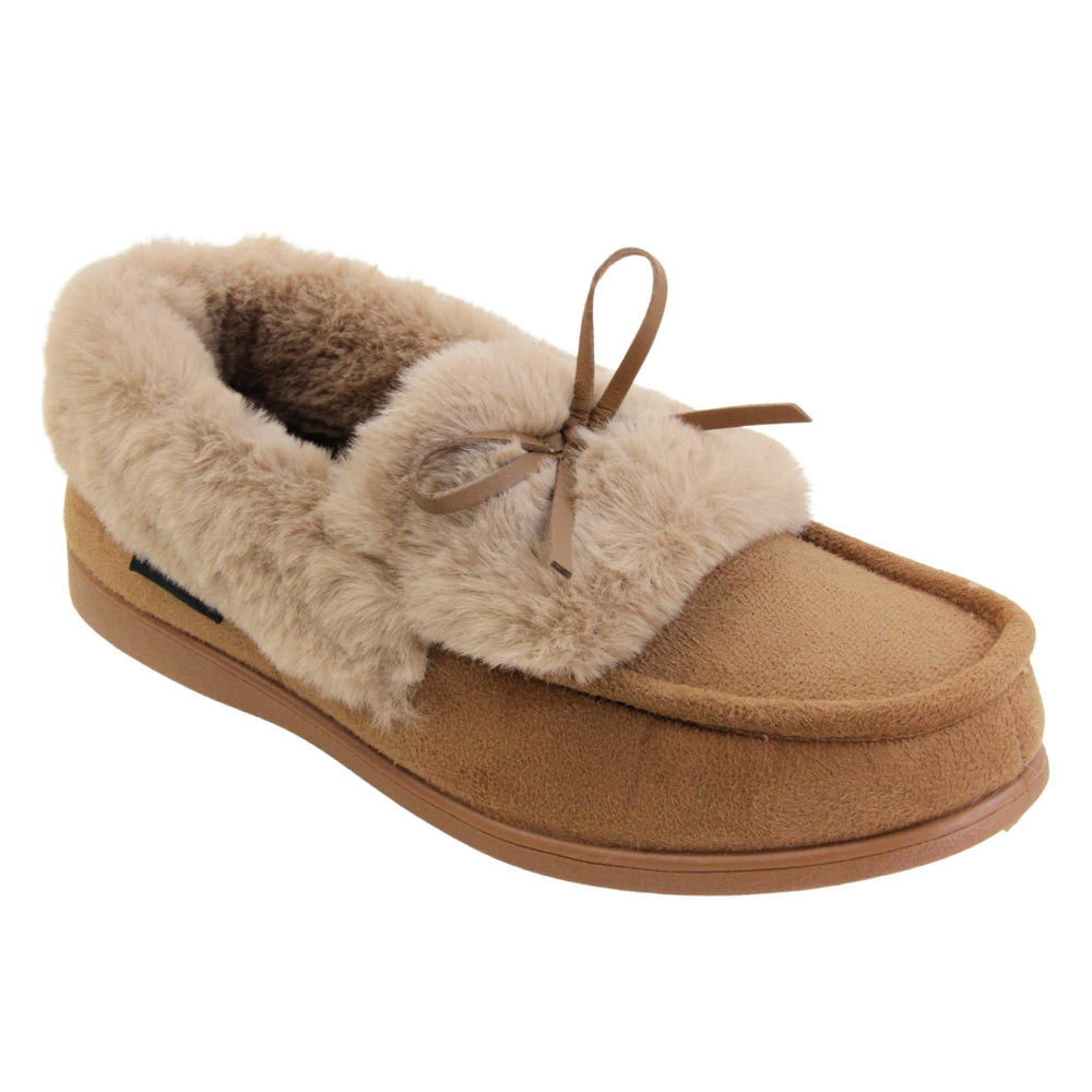 Moccasin slippers womens. Moccasin style slipper with a brown camel coloured faux suede upper and bow to the top. Light brown faux fur collar, tongue and lining. Brown rubber sole. Right foot at an angle.