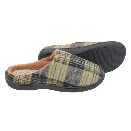 Mule slippers for men. Mule style slippers with fleecy yellow and grey tartan uppers. Brown terry lining and firm black sole. Both feet from a side profile with the left foot on its side behind the the right foot to show the sole.