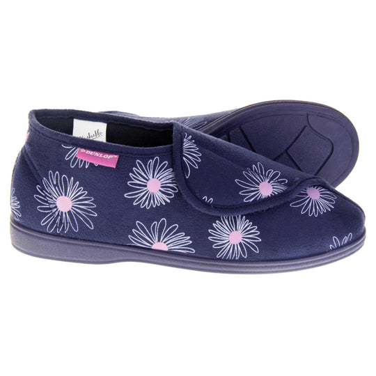 Navy blue slippers. Womens bootie style slipper with a navy blue textile upper with a white and pink flower print. Touch fasten tab to the top and blue textile lining. Firm navy sole. Both feet from a side profile with the left foot on its side behind the the right foot to show the sole.