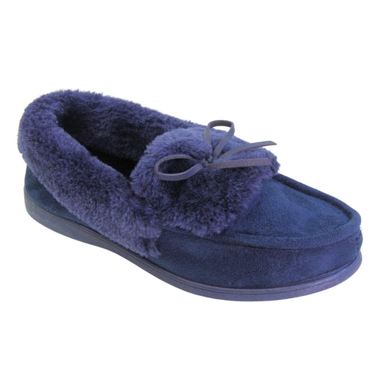 Navy moccasin slippers. Moccasin style slipper with a navy blue faux suede upper and bow to the top. Navy faux fur collar, tongue and lining. Navy rubber sole. Right foot at an angle.