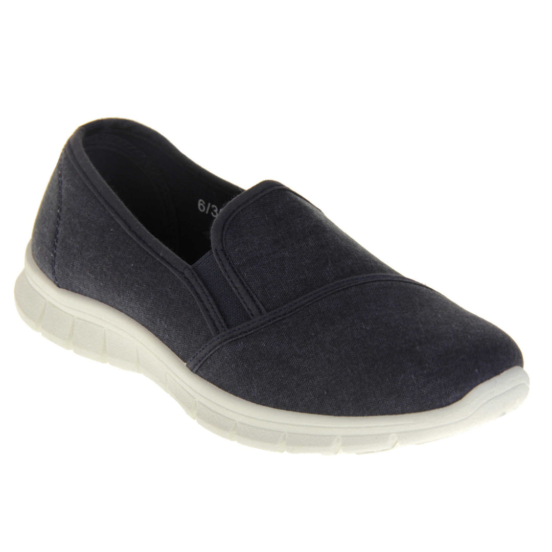 Navy slip on shoes. Women's plimsoll style shoes with a navy blue canvas upper. Navy elasticated gusset. Chunky white sole. Right foot at an angle.