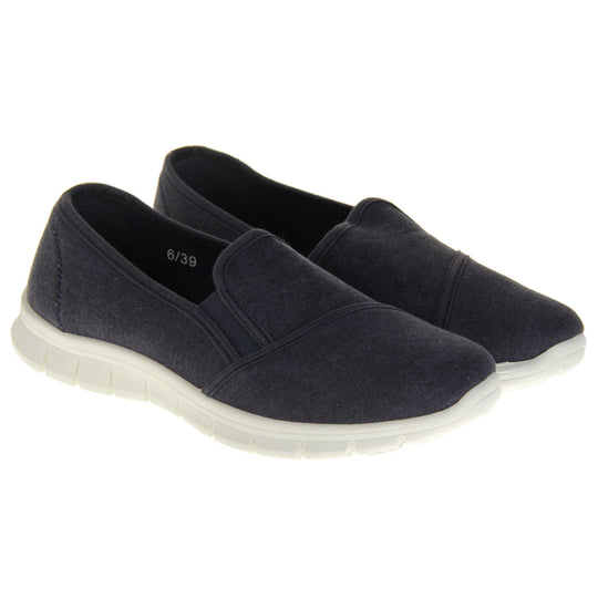 Navy slip on shoes. Women's plimsoll style shoes with a navy blue canvas upper. Navy elasticated gusset. Chunky white sole. Both feet together at a slight angle.