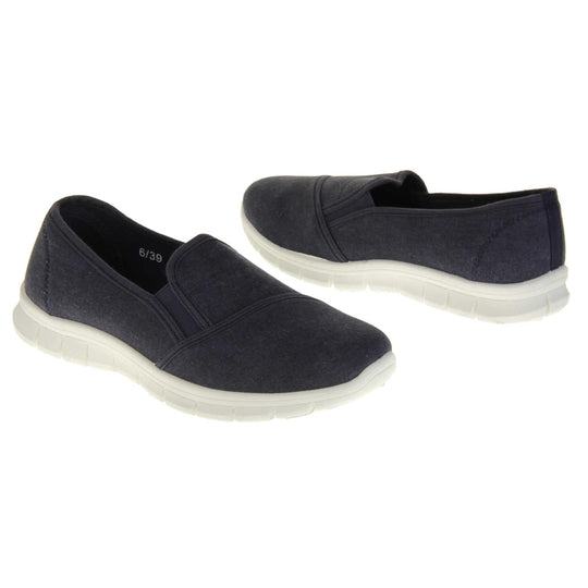 Navy slip on shoes. Women's plimsoll style shoes with a navy blue canvas upper. Navy elasticated gusset. Chunky white sole. Both feet at an angle facing top to tail.