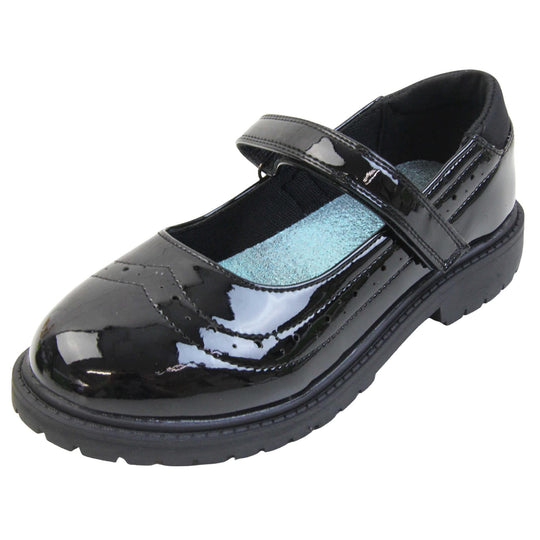 Older girls school shoes. Mary Jane style shoes with black patent faux leather uppers. With a touch fasten strap over the foot and brogue detailing around the top of the shoe. Black textile lining with a metallic blue insole. Chunky black sole with slight heel. Left foot at an angle.