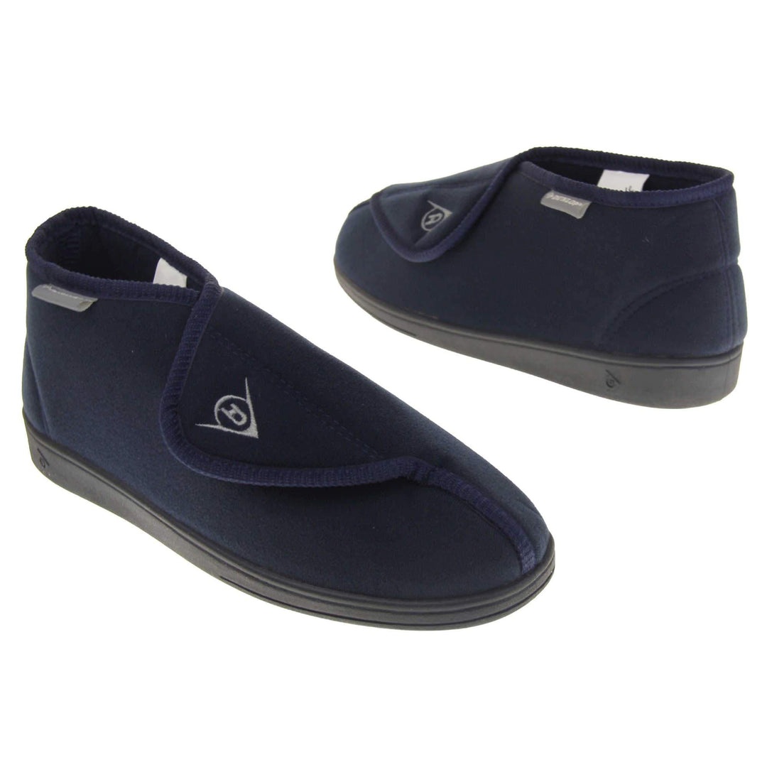 Orthopaedic slipper boots. Mens orthopaedic slippers in an ankle boot style. With a soft navy textile upper and blue textile lining. With an adjustable touch close top with a grey Dunlop logo on. Small grey label to the outer side edge with Dunlop written on. Thick black outdoor sole. Both feet at a slight angle facing top to tail.