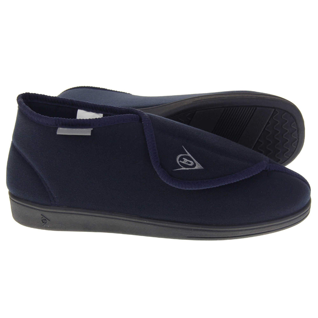 Orthopaedic slipper boots. Mens orthopaedic slippers in an ankle boot style. With a soft navy textile upper and blue textile lining. With an adjustable touch close top with a grey Dunlop logo on. Small grey label to the outer side edge with Dunlop written on. Thick black outdoor sole. Both feet from side profile with the left foot on its side to show the sole.