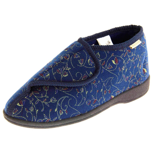 Orthopaedic slippers. Womens bootie style slipper with a navy blue textile upper with vine and flower embroidered design. Touch fasten tab to the top and blue textile lining. Firm black sole. Left foot at an angle.
