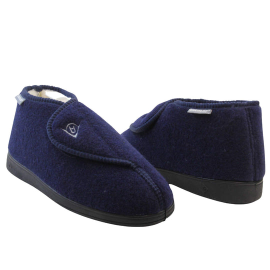 Orthopaedic slippers. Mens orthopaedic slippers in an ankle boot style. With a navy blue felt upper and white fleece lining. With an adjustable touch close top with a grey Dunlop logo on. Small grey label to the outer side edge with Dunlop written on. Thick black outdoor sole. Both feet at a slight angle facing top to tail.