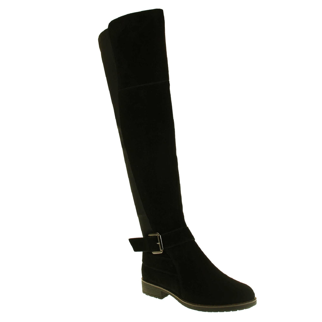 Over the knee flat suede boots. Tall boots that go above the knee in a black suede upper. Strap with buckle around the ankle. Black outsole with slight heel. Right foot at an angle.