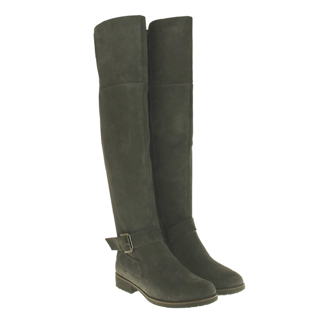 Over the knee grey suede boots. Tall boots that go above the knee in a grey suede upper. Strap with buckle around the ankle. Grey outsole with slight heel. Both feet together from an angle.